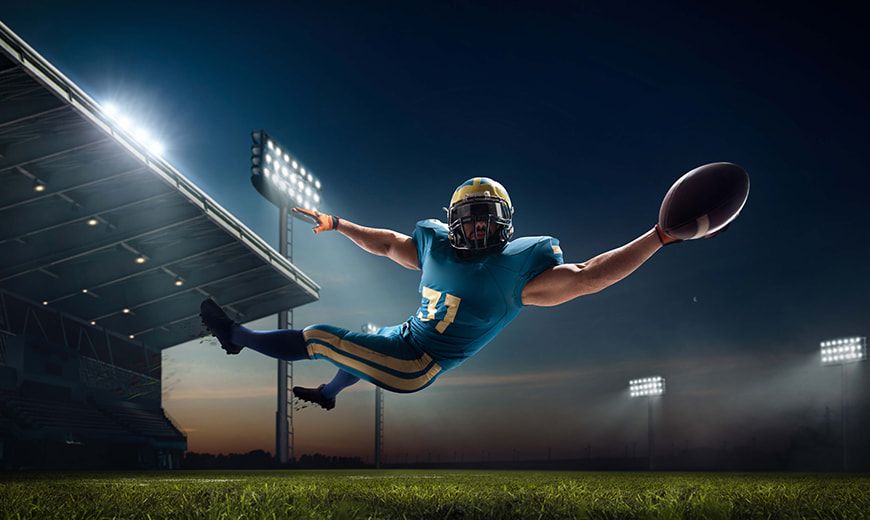 American football player catching ball on field